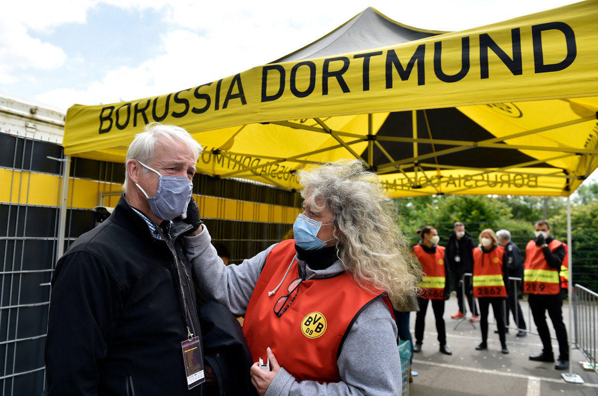A member of the TV broadcast crew gets his temperature taken at Dortmund's stadium.